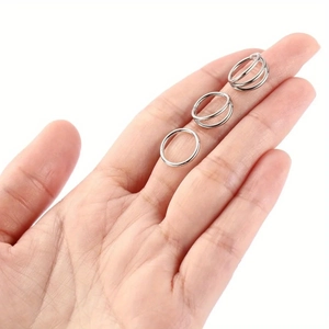 Detailed view of silver stainless steel single, double, and triple hoop rings for piercing