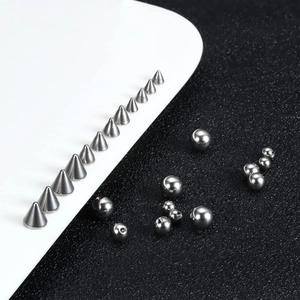 Detailed macro of stainless steel piercing spikes and balls showing internal thread structure