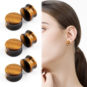 Macro view of saddle ear plugs made of natural tiger eye stone with polished finish