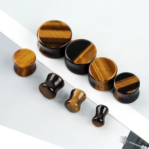 Macro shot of double flared tiger eye stone ear plugs showing natural polished texture