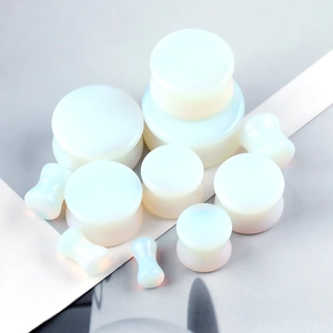 Collection of various sized opalite ear plugs with translucent milky white finish