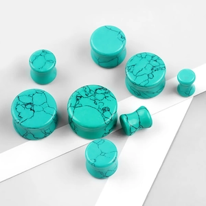 Macro view of turquoise marble ear plugs in multiple sizes with double flared design