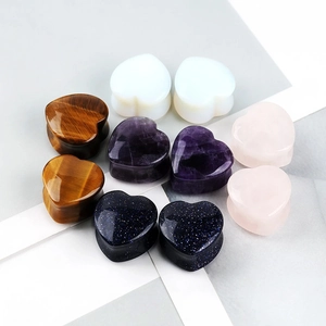 Macro detail of heart-shaped ear plugs in tiger eye, amethyst and opal natural stones