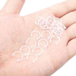 Set mit 20 transparenten Acryl Hufeisen Nasenringen und Piercing Retainern in der Hand