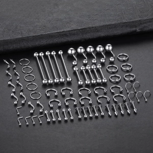 Gros plan d'un kit de 120 piercings en acier inoxydable avec anneaux et clous