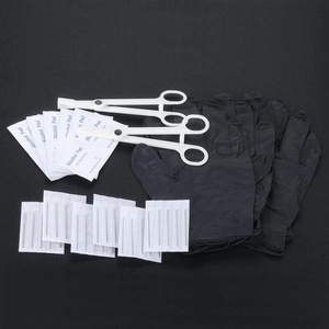 Détail du kit de piercing avec aiguilles stériles, gants noirs et tampons d'alcool