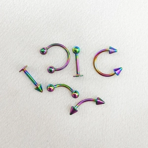 Set piercing arcobaleno in acciaio con anelli a ferro di cavallo, sfere e punte coniche