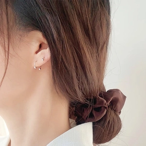 Modella che indossa un piercing a ferro di cavallo e un elastico per capelli in velluto