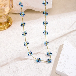 Collar floral bohemio con flores de cristal azul y púrpura en una cadena dorada
