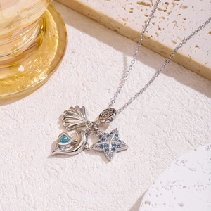Dettaglio di una collana nautica in argento con ciondoli a conchiglia, delfino e stella marina