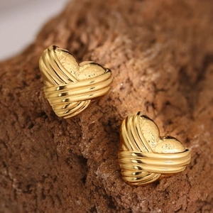 Macro shot of gold-plated 304 stainless steel heart earrings with textured stripes