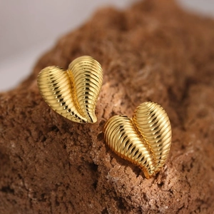 Macro shot of 304 stainless steel heart earrings with textured golden finish on rock