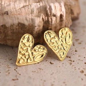 Detailed macro view of 304 stainless steel gold heart earrings with hammered vintage texture