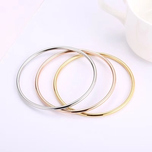 Detailed view of 3mm minimalist bangles in gold, silver, and rose gold polished finishes