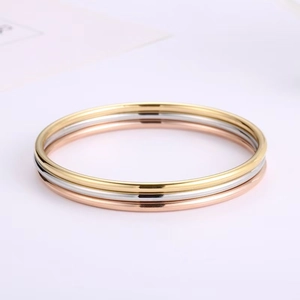 Detail of three-tone interlocking stackable rings in gold, silver, and rose gold finishes
