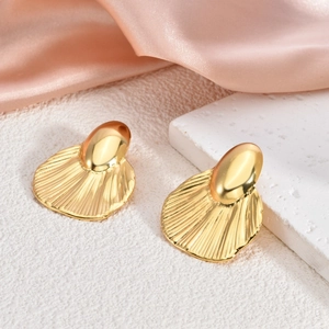 Macro shot of 18K gold plated irregular earrings with pleated texture on silk background