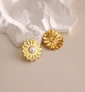Detail of floral gold-plated earrings featuring white pearls and elegant daisy petals