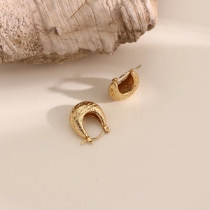 Detail of 18k gold plated U-shape earrings with a textured hammered finish on metal