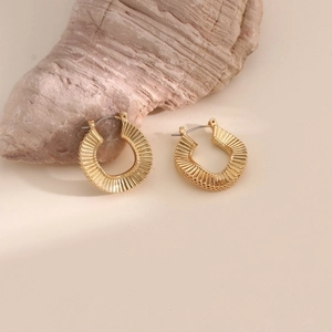 Close-up of 18k gold plated stainless steel C-shaped earrings with radial rib texture