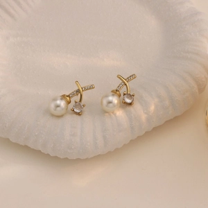 Eleganti orecchini a perno dorati con design a X in cristallo e perle bianche circolari
