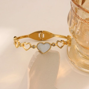 Elegant gold titanium steel heart bangle with white shell inlay and zircon accents