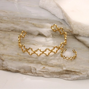 Detailed view of gold plated stainless steel clover hollow cuff bracelet and ring set