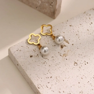 Pendientes de trébol de cuatro hojas bañados en oro con perlas blancas sobre base pétrea