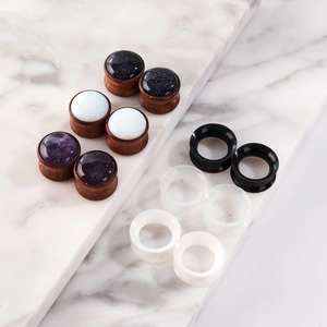 Macro shot of assorted wood and silicone ear plugs displayed on marble slabs