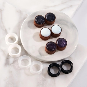6 pairs wood and stone ear gauge set with silicone tunnels on marble background
