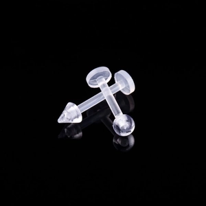 Macro shot of two transparent acrylic lip studs with ball and cone tops on black background