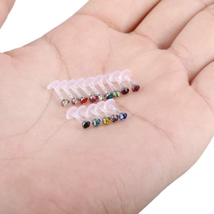 Set di 16 piercing labret in acrilico con pietre di zircone colorate tenuti in mano
