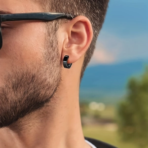Pendiente de aro para hombre de acero inoxidable negro usado por un modelo afuera