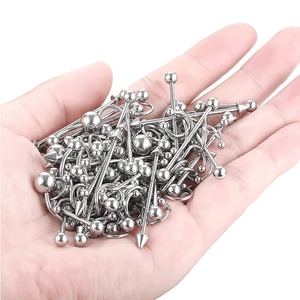 Primer plano de un set de piercings de acero inoxidable con varios diseños en la mano