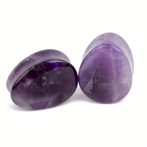 Gros plan sur des écarteurs en améthyste en forme de goutte avec textures violettes