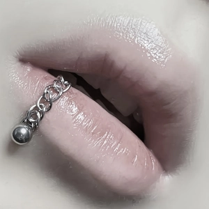 Detailed close-up of a silver stainless steel lip chain with a small polished metal bead