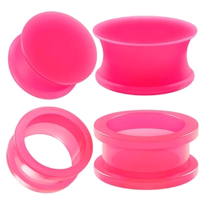 Detail of neon pink acrylic silicone ear plugs and hollow tunnels jewelry set