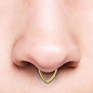 Macro detail of polished gold V-shaped nose ring on septum piercing for piercing jewelry