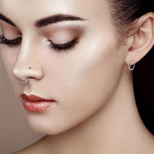 Primer plano detallado de set de piercings de nariz de acero con diseños de corazón y estrella