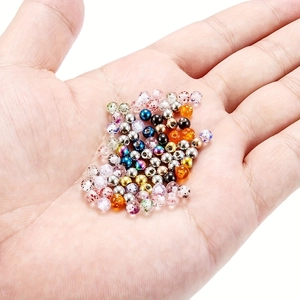 Mezcla de cuentas de piercing de acrílico y acero inoxidable mostradas en la mano