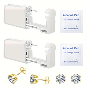 Close-up of disposable ear piercing kit with two gold studs and alcohol prep pads