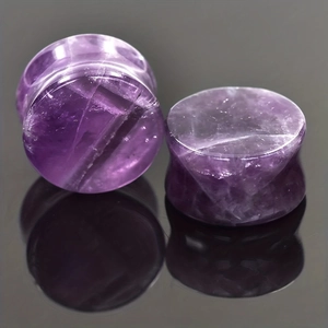 Pair of purple amethyst double flared ear plugs with natural stone texture on mirror