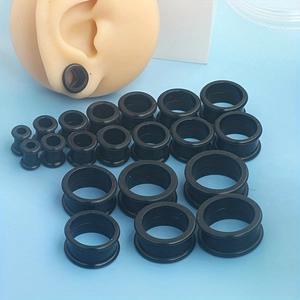 Detail view of black silicone ear tunnels in multiple sizes with ear model demonstration