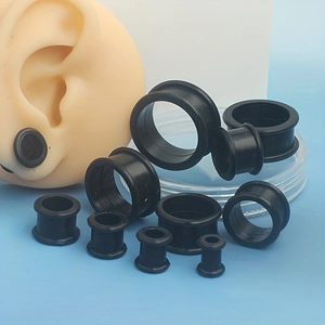 Detailed set of black silicone ear tunnels in multiple sizes shown on a blue background