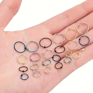 Set van kleurrijke roestvrijstalen captive bead ringen in de hand voor schaalvergroting