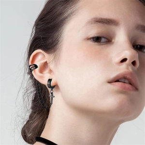 Detail eines schwarzen Gothic-Ohrrings mit Ohrmanschette, Kreuzanhänger und Metallkette