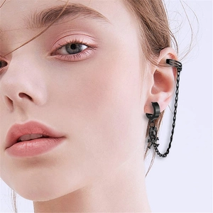 Nahaufnahme der schwarzen Punk-Ohrklemme mit Totenkopf-Anhänger und feiner Metallkette
