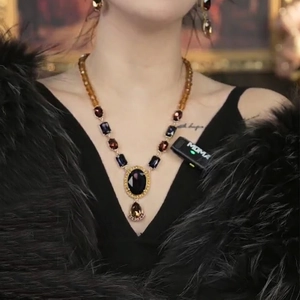 Luxury gold-plated necklace with oval purple gemstone and amber bead chain on model