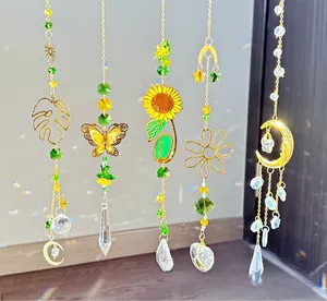 Detailed view of bohemian crystal sun catchers with golden motifs and faceted beads