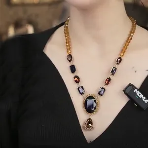 Macro detail of a vintage teardrop pendant necklace with multi-color gemstone clusters