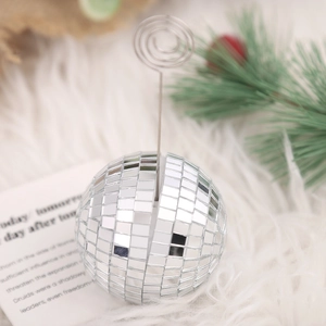 Silver disco ball place card holder for wedding table decor on white plush background